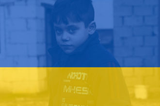 kuvassa ukrainalainen poika ja ukrainan lippu